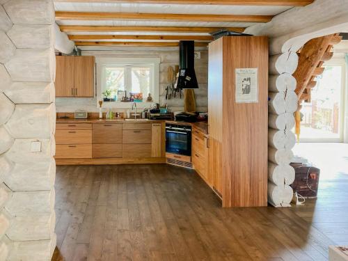 a kitchen with wooden cabinets and a stone wall at Modern Log Cabin On Adelsö in Adelsö