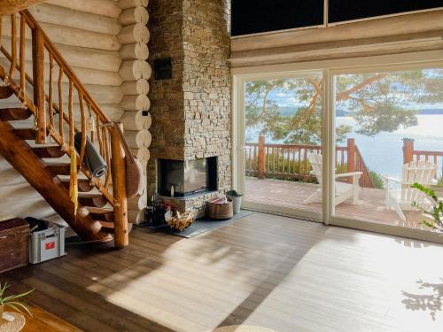 a living room with a staircase and a fireplace at Modern Log Cabin On Adelsö in Adelsö