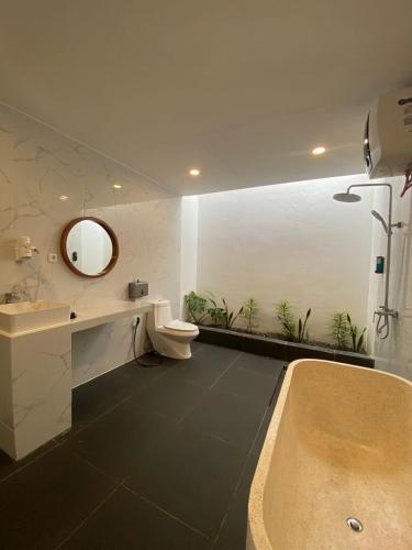 a bathroom with a tub and a sink and a mirror at MeZZO Villa in Ayah