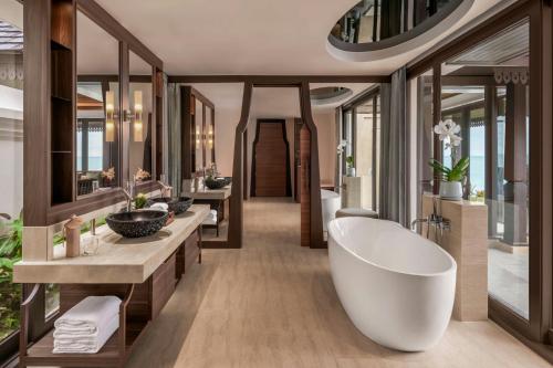 a bathroom with a large tub and two sinks at The Ritz-Carlton, Koh Samui in Choeng Mon Beach