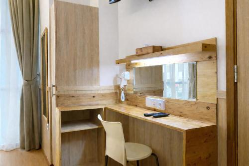 a room with a wooden desk and a chair at Smart Hotel Thamrin Jakarta in Jakarta