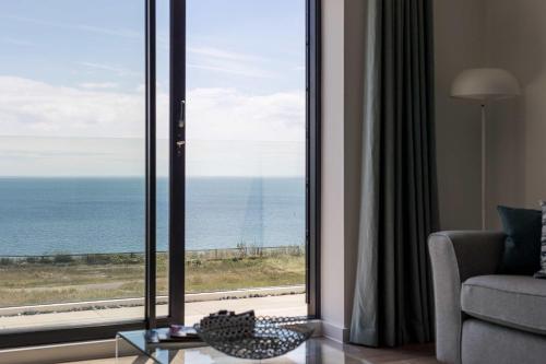 a living room with a view of the ocean at Beachcliff - On the Seafront with Two Balconies in Bournemouth