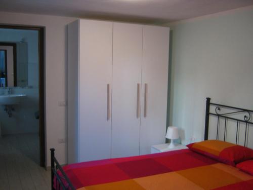 a bedroom with a bed and a white cabinet at La Casetta DI Luciano in Foligno