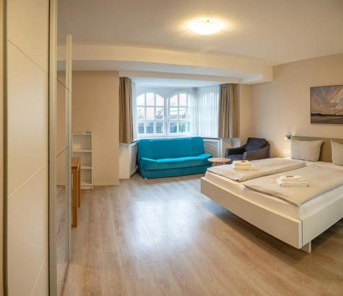 a hotel room with a bed and a blue couch at Lieblingsplatz Hotel Seedeich in Grömitz