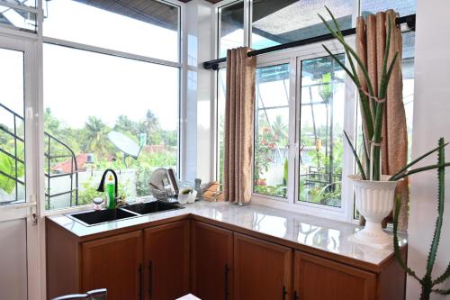 a kitchen with a sink and a large window at Hureshan Villa in Negombo