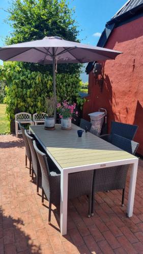 a white table with chairs and an umbrella at Stouwhuset Øster Hurup in Hadsund