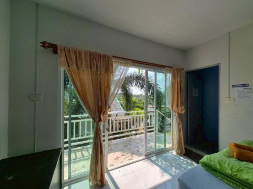a room with a large window with a view of a balcony at Sam roi yot Sea sight Resort in Sam Roi Yot