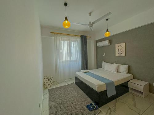 a bedroom with a bed and two lights at Aqua Epic Residence in Mombasa