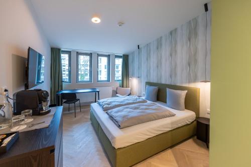 ein Schlafzimmer mit einem Bett und einem Schreibtisch in der Unterkunft qnorke Hotel in Berlin