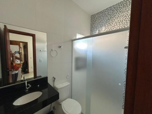 a bathroom with a toilet and a sink and a mirror at Casa Terra in Prado