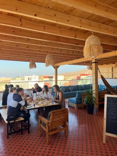a group of people sitting at tables in a restaurant at KAZA Wave Surf camp in Imsouane