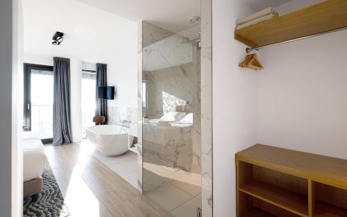 a bathroom with a tub and a sink and a shower at Maris Apartments in Egmond aan Zee