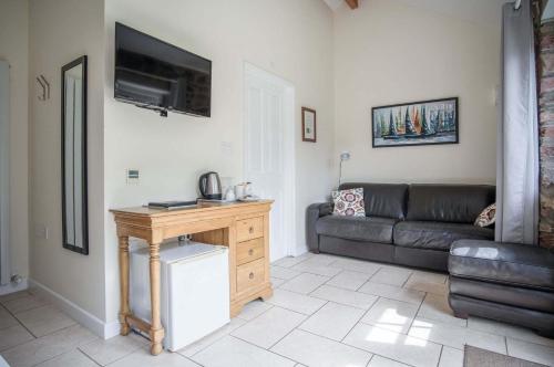 a living room with a couch and a television at Gofan - 1 Bedroom - St Ishmaels in Saint Ishmaels