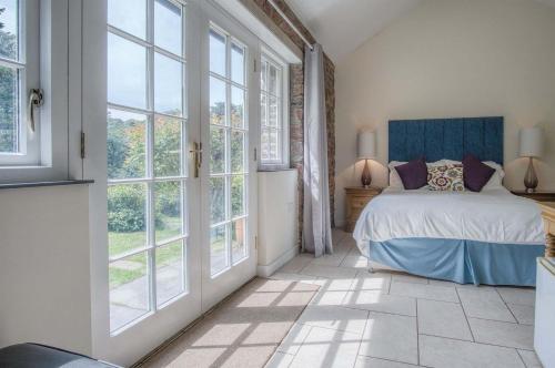 a bedroom with a bed and large windows at Gofan - 1 Bedroom - St Ishmaels in Saint Ishmaels