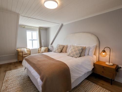 a bedroom with a large white bed and a window at Salt & Butter in Hermanus