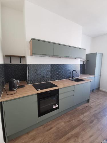 a kitchen with a sink and a stove top oven at Victoria Guest House in Ramsgate