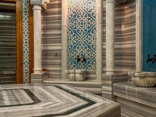 a rendering of a room with a tub and columns at Qoople Elite Admiral Apartment in Alanya