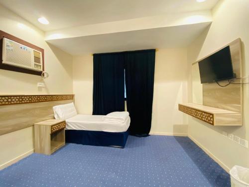 a small room with a bed and a television at Emaar million6 in Quai