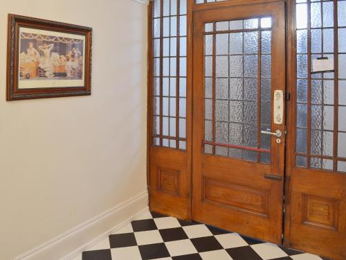 a wooden door in a room with a checkered floor at Sandfield The Promenade in Southport