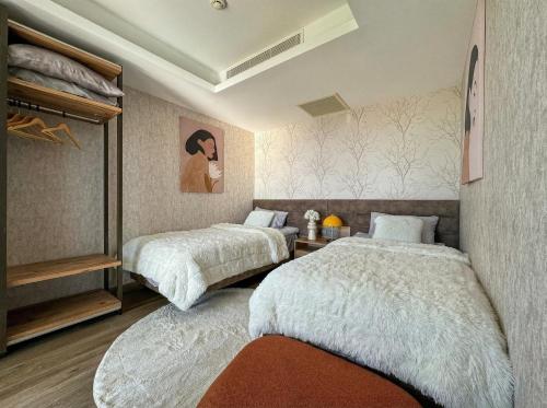 a bedroom with two beds and a painting on the wall at Qoople Elite Admiral Apartment in Alanya