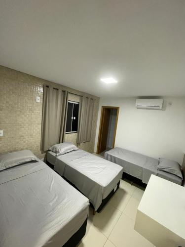 a hotel room with two beds and a table at AL&V Hotel in Santa Tereza do Oeste