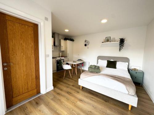 a bedroom with a bed and a wooden door at Garden Studio in Bristol