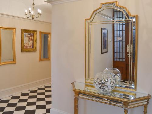 a mirror on a table in a room with a checkered floor at Sandfield The Promenade in Southport