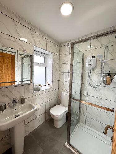 a bathroom with a shower and a toilet and a sink at Garden Studio in Bristol