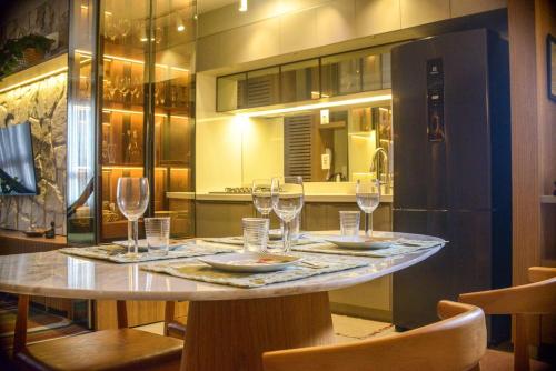a table in a kitchen with wine glasses on it at Apê catedral centro in Goiânia