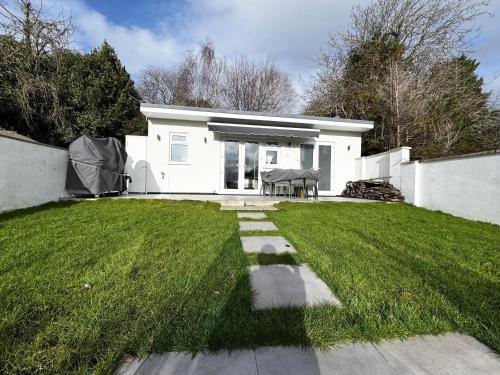 a white house with a grassy yard at Garden Studio in Bristol