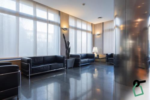 a living room with couches and a lobby with windows at Hotiday Milano Navigli in Milan