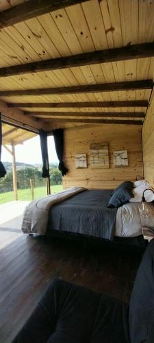 a bedroom with a large bed with a wooden ceiling at Cabanas do Arvoredo in São José do Cerrito