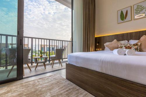 a bedroom with a large bed and a balcony at Nasma Luxury Stays - Opulent family escape in coastal community in Ras al Khaimah