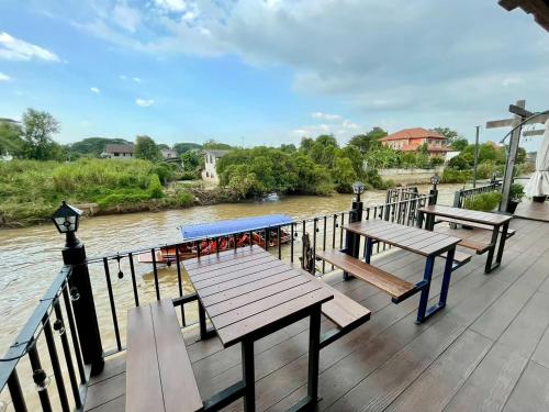 a deck with benches and a view of a river at Bigcountry Tour Stay Ayutthaya in Phra Nakhon Si Ayutthaya