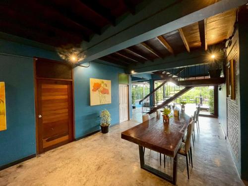 a dining room with a wooden table and blue walls at Bigcountry Tour Stay Ayutthaya in Phra Nakhon Si Ayutthaya