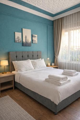 a bedroom with a large bed with blue walls at Gold Coast Hostel in Antalya