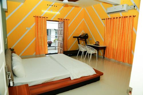 a bedroom with a bed and a table and chairs at Greeny Homestay in Cochin