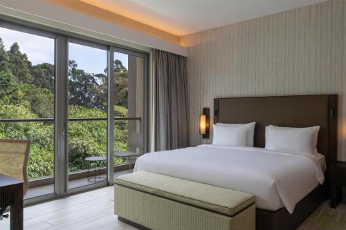 a bedroom with a large bed and a large window at Radisson Blu Hotel & Residence Nairobi Arboretum in Nairobi