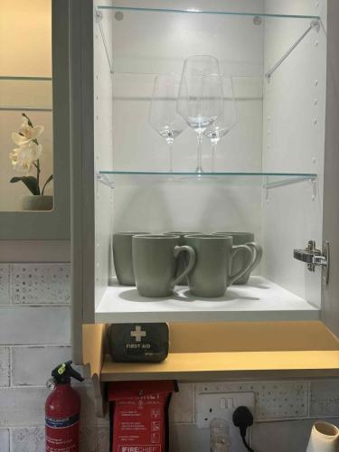a cabinet with two cups and a wine glass at Apartment No 4 in Bridlington