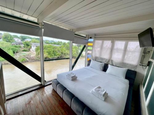 a bedroom with a bed with a view of a river at Bigcountry Tour Stay Ayutthaya in Phra Nakhon Si Ayutthaya