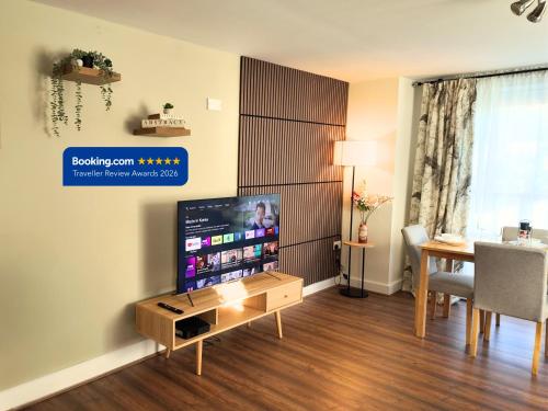 a living room with a television and a table with a dining room at Luxury Spacious Apartment- Sleeps 4 Loughborough in Loughborough