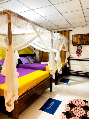 a bedroom with two beds and a canopy at Mango Villa - Panama Near Arugam Bay in Panama