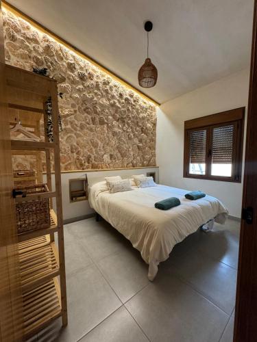 a bedroom with a bed and a stone wall at Villa Loma de Bas 1 y 2 in Águilas