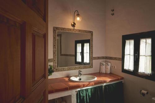 a bathroom with a sink and a mirror at ALOJAMIENTO TURISTICO- AGROTURISMO Dehesa La Pared in Chillón