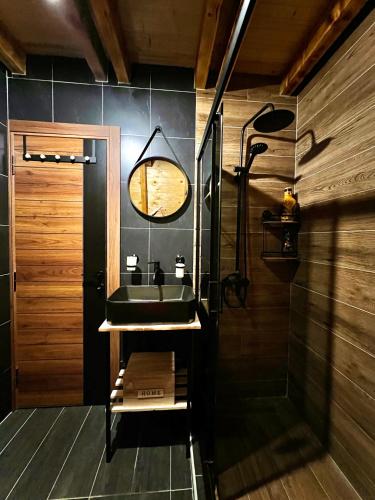 a bathroom with a sink and a clock on the wall at Ataraksija in Mijakovići
