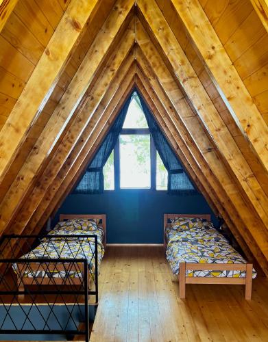 two beds in a attic room with a window at Ataraksija in Mijakovići