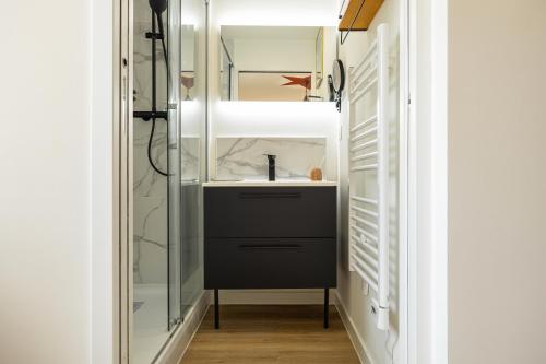 a bathroom with a sink and a mirror at 304 Chanzy - T1 Spacieux - Gare & Centre - Wifi in Le Mans