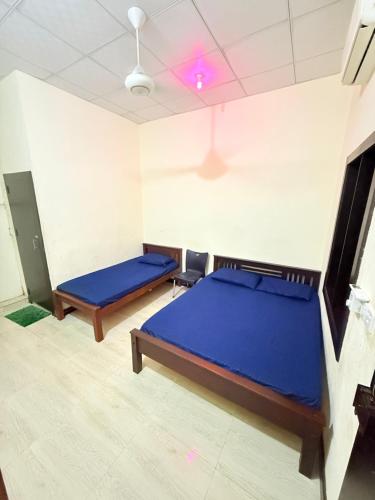 a bedroom with two beds and a purple ceiling at SSF Green Home in Akkaraipattu