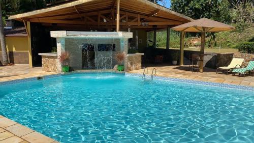 a large swimming pool with a water fountain at Della Vegas Economy in Serra Negra
