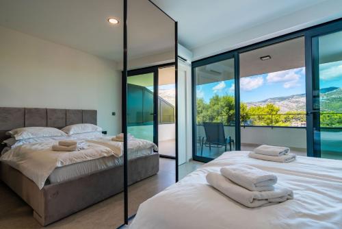 two beds in a bedroom with glass walls at Korcula Hill in Korčula